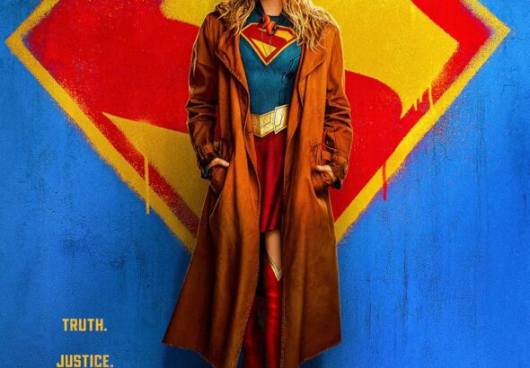 Poster film Supergirl (2026) dengan karakter utama Kara Zor-El mengenakan kostum Supergirl lengkap dengan jaket panjang, berpose di depan latar belakang logo Superman yang ikonik.
