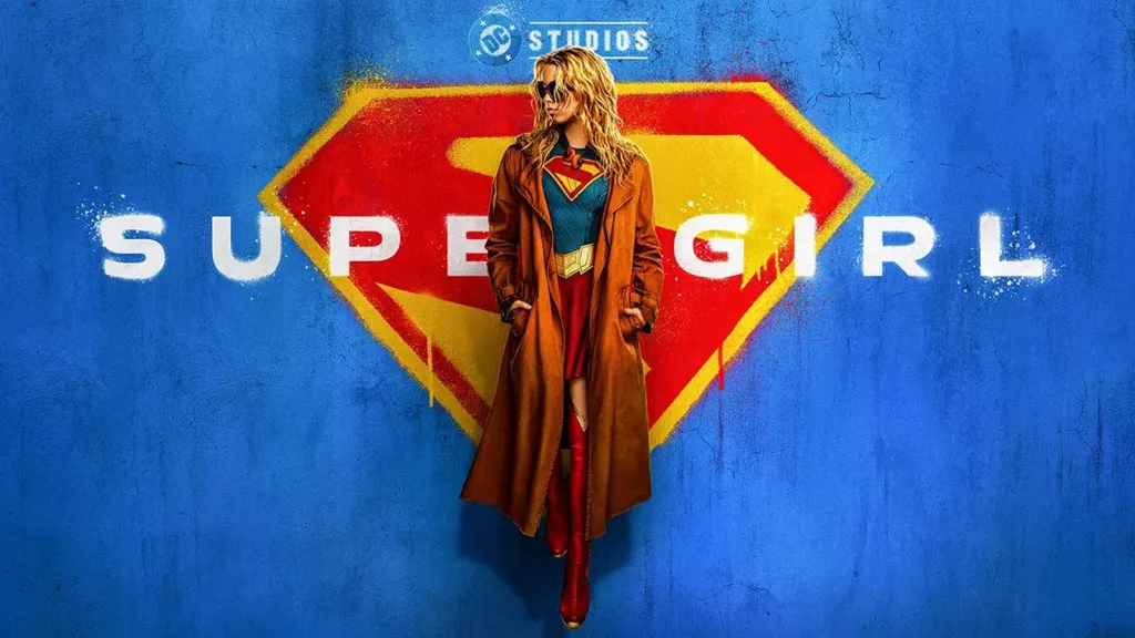 Poster film Supergirl (2026) dengan karakter utama Kara Zor-El mengenakan kostum Supergirl lengkap dengan jaket panjang, berpose di depan latar belakang logo Superman yang ikonik.