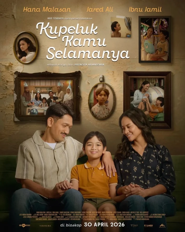 Poster film Kupeluk Kamu Selamanya menampilkan keluarga kecil yang hangat—ayah, ibu, dan anak duduk bersama di sofa dengan latar dinding penuh bingkai kenangan, mencerminkan kasih sayang dan kebersamaan.
